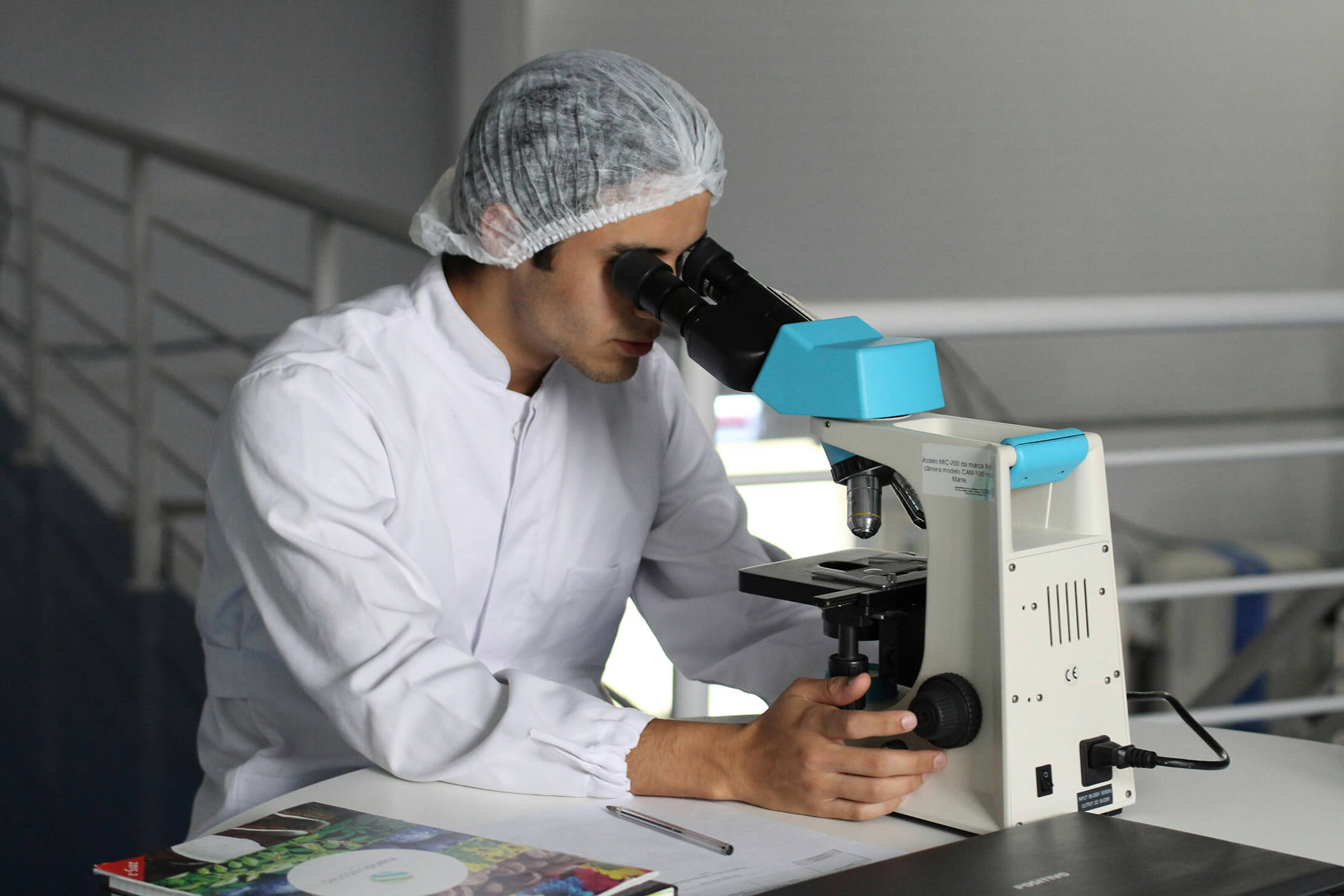 Man using microscope to examine samples in a lab